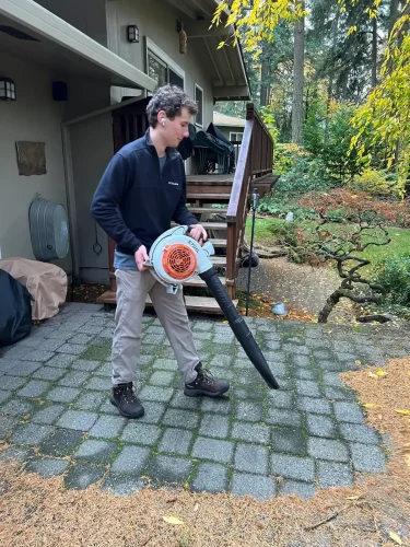 Owner blows debris using a leaf blower.